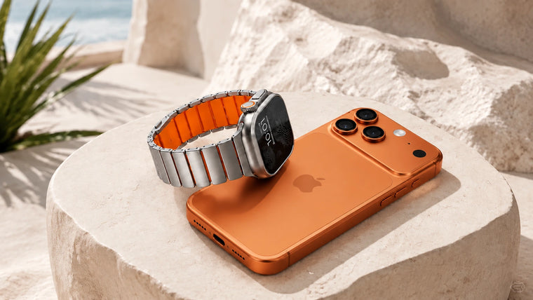 Titanium watch band with orange lining beside an orange phone on a stone pedestal