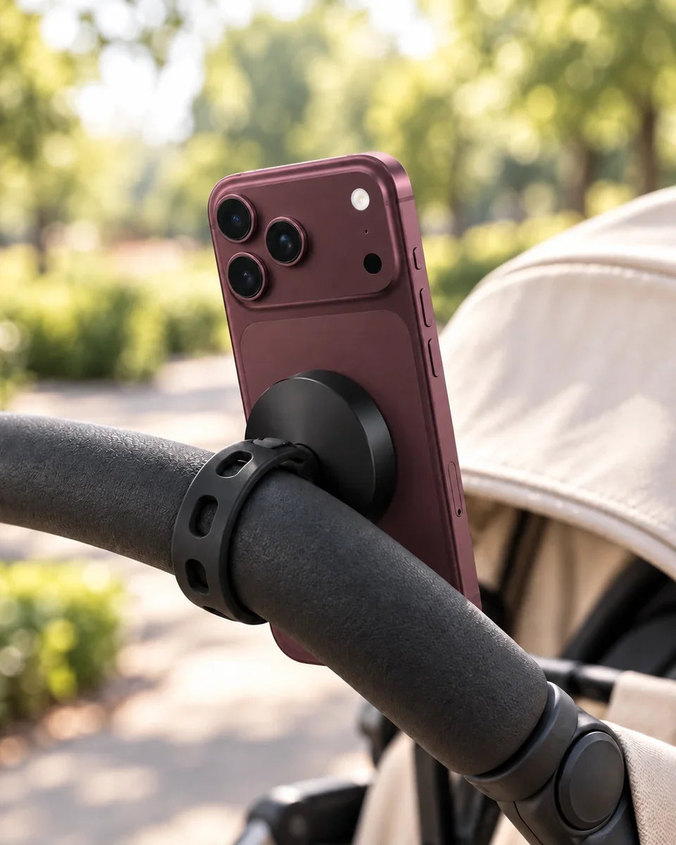 A magnetic phone holder secured directly around a stroller handle with its flexible perforated strap.