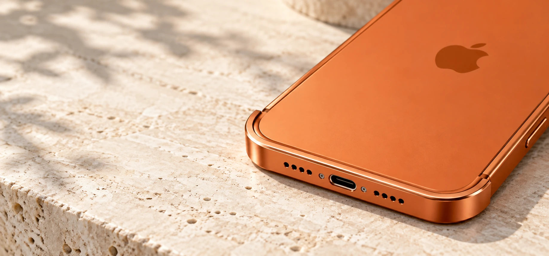 Close-up of the curved orange metal bumper around the phone's bottom edge.